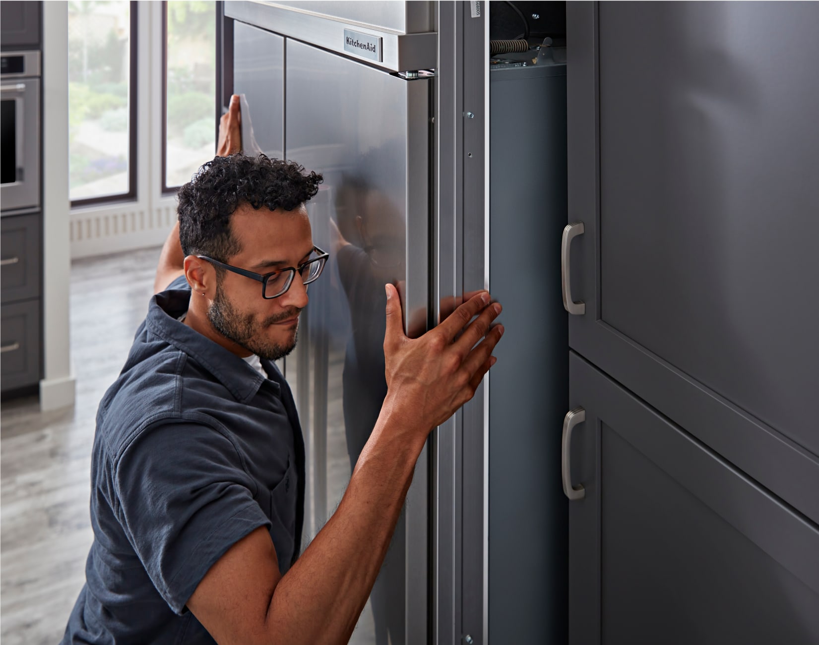 A professional installing a KitchenAid® built-in refrigerator.