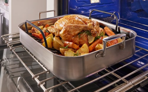 A turkey and vegetables in an air fry basket in a KitchenAid® wall oven