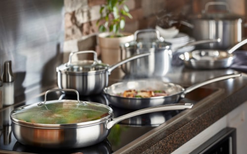 A stainless steel skillet on a KitchenAid brand induction cooktop.