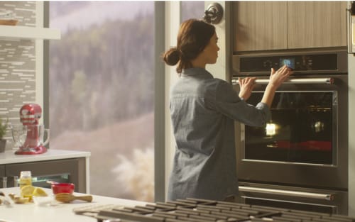 Person selecting settings on KitchenAid® wall oven