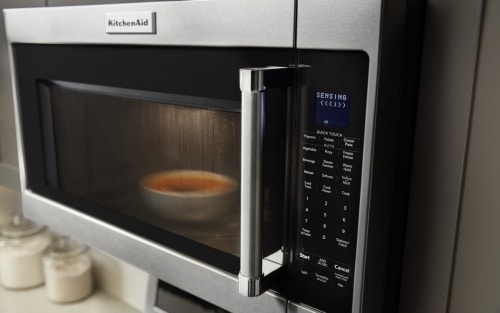 Food cooking in the microwave with SENSING shown on the display