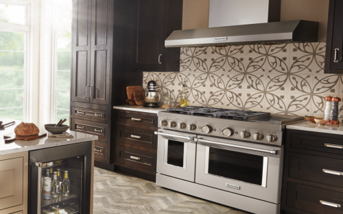 Modern kitchen featuring KitchenAid® stainless steel range and range hood