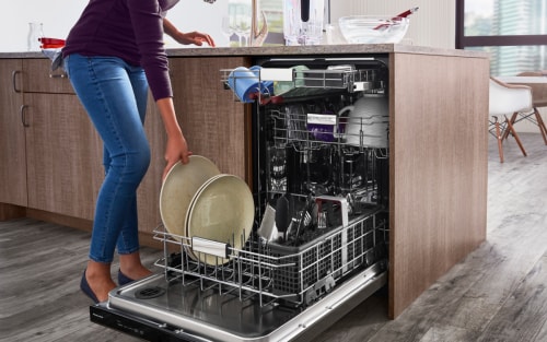 Woman loading dishes into a dishwasher