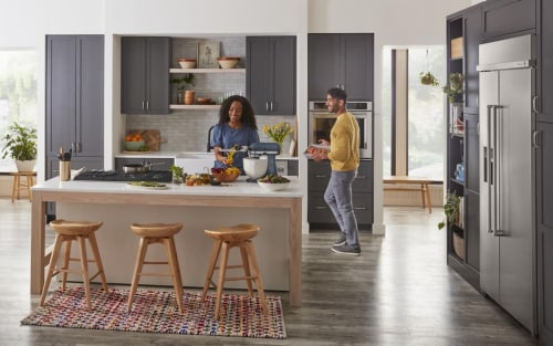 Two people in an open concept kitchen with a kitchen island